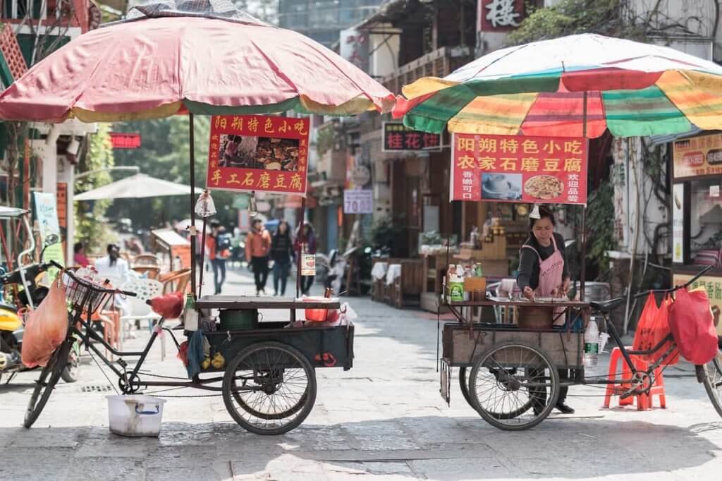 Two street food carts in China stand alone in a sunny afternoon