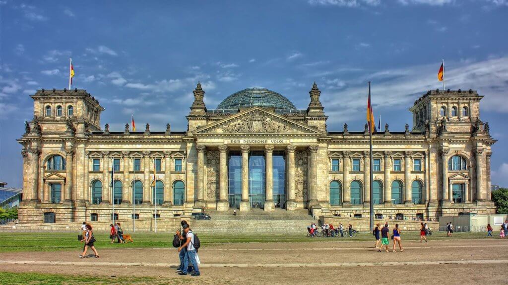 A German government building framed by standing German flags