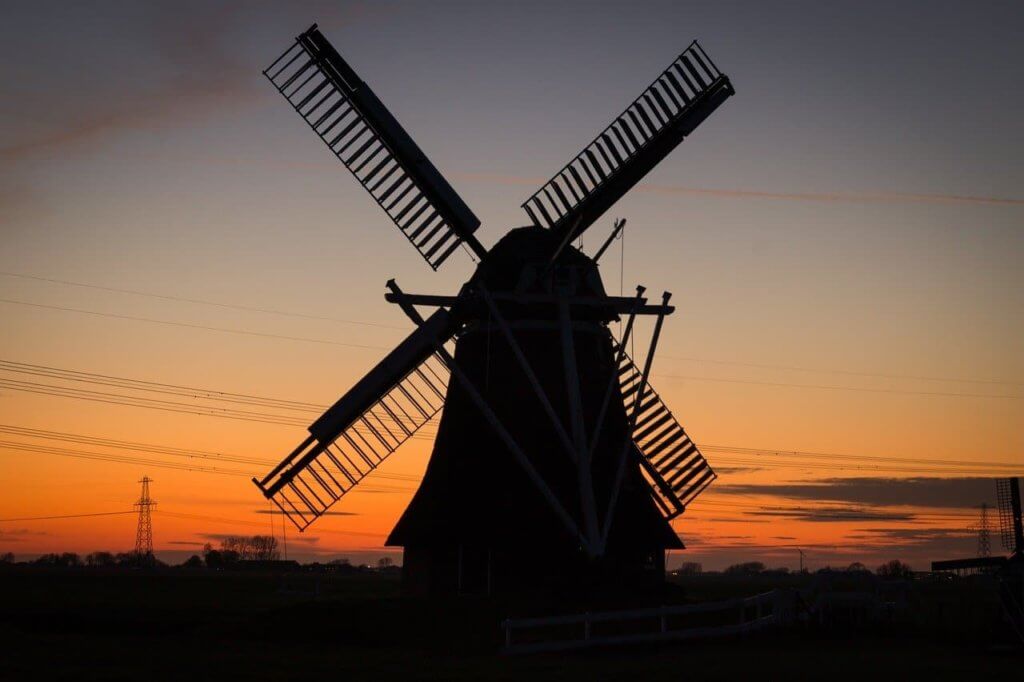 A Windmill stands in front of a dawn in The Netherlands