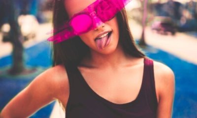 long-haired woman with sunglasses sticks her tongue out