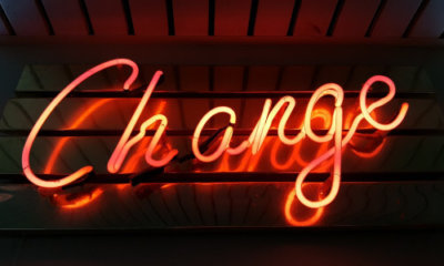 red neon sign spelling out the word change