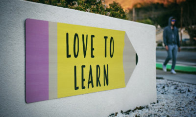 Yellow and lilac pencil-shaped sign with the words love to learn
